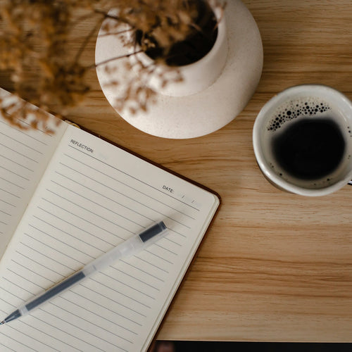 An open journal and pen laid out for a morning writing practice